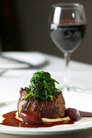 A glass of fine red wine with a filet mignon